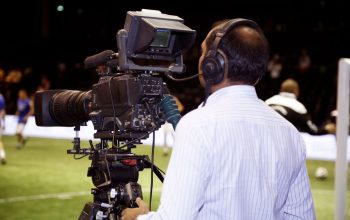 Sebuah kameramen yang merekam pertandingan sepak bola di stadion, menangkap aksi dalam video.