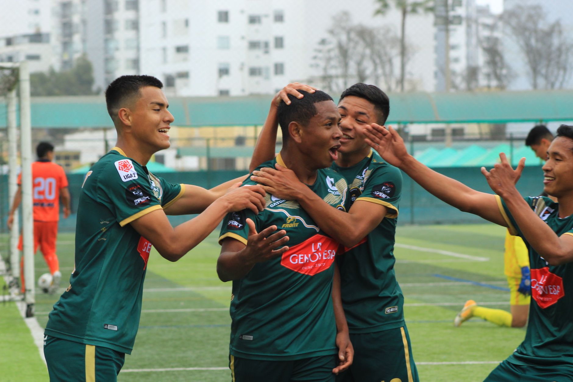Pemain sepak bola merayakan gol di lapangan dengan semangat dan kerja sama tim.