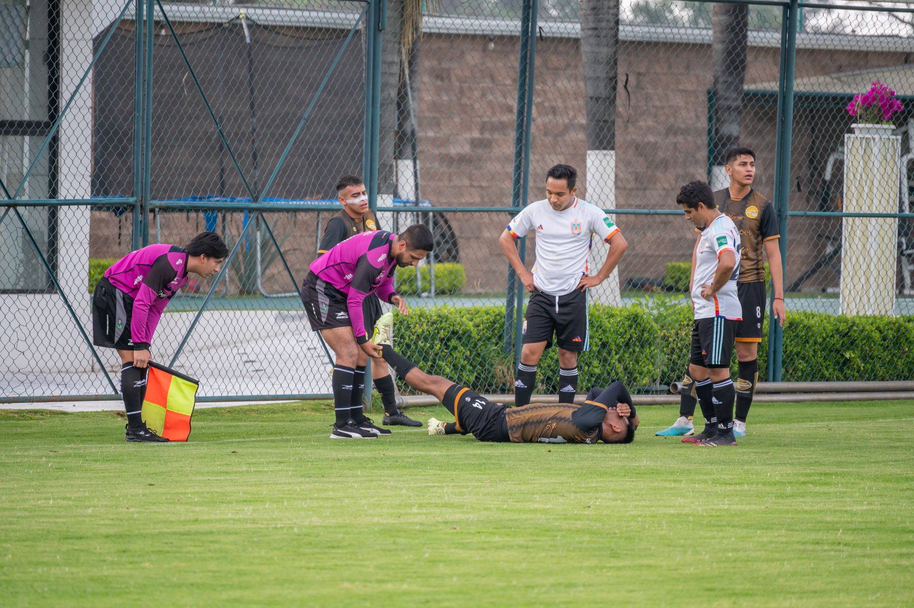 Pemain sepak bola yang cedera di lapangan dengan bantuan rekan setim dan wasit di Texcoco, Meksiko.