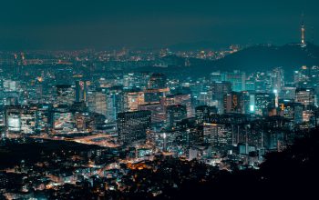 Pemandangan menakjubkan dari cakrawala kota yang terang benderang di malam hari, menampilkan kehidupan urban.