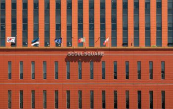 Fasad merah Seoul Square dengan berbagai bendera internasional yang dipajang.