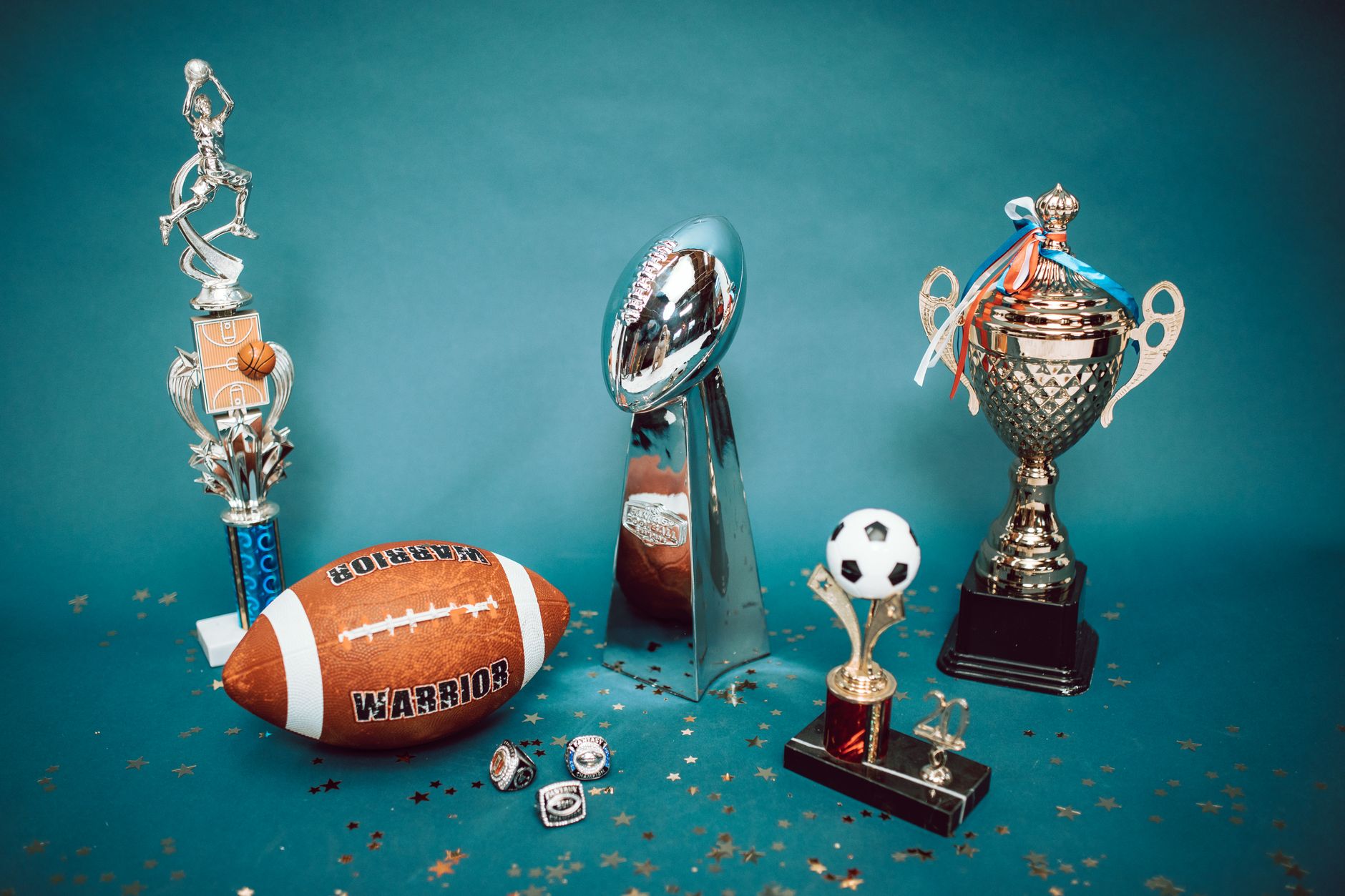 Koleksi trofi olahraga dan barang memorabilia yang mewakili pencapaian dan kesuksesan di latar belakang biru.