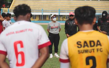 Tim sepak bola berkumpul dalam huddle di lapangan terbuka di Jakarta, Indonesia.