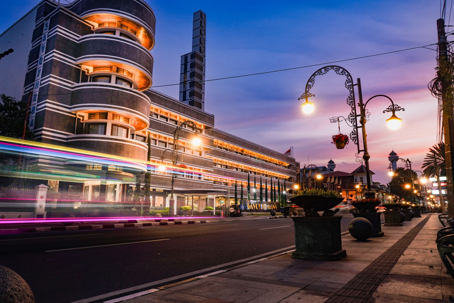 Arsitektur Art Deco yang diterangi cahaya senja di pemandangan jalanan Bandung, Indonesia.