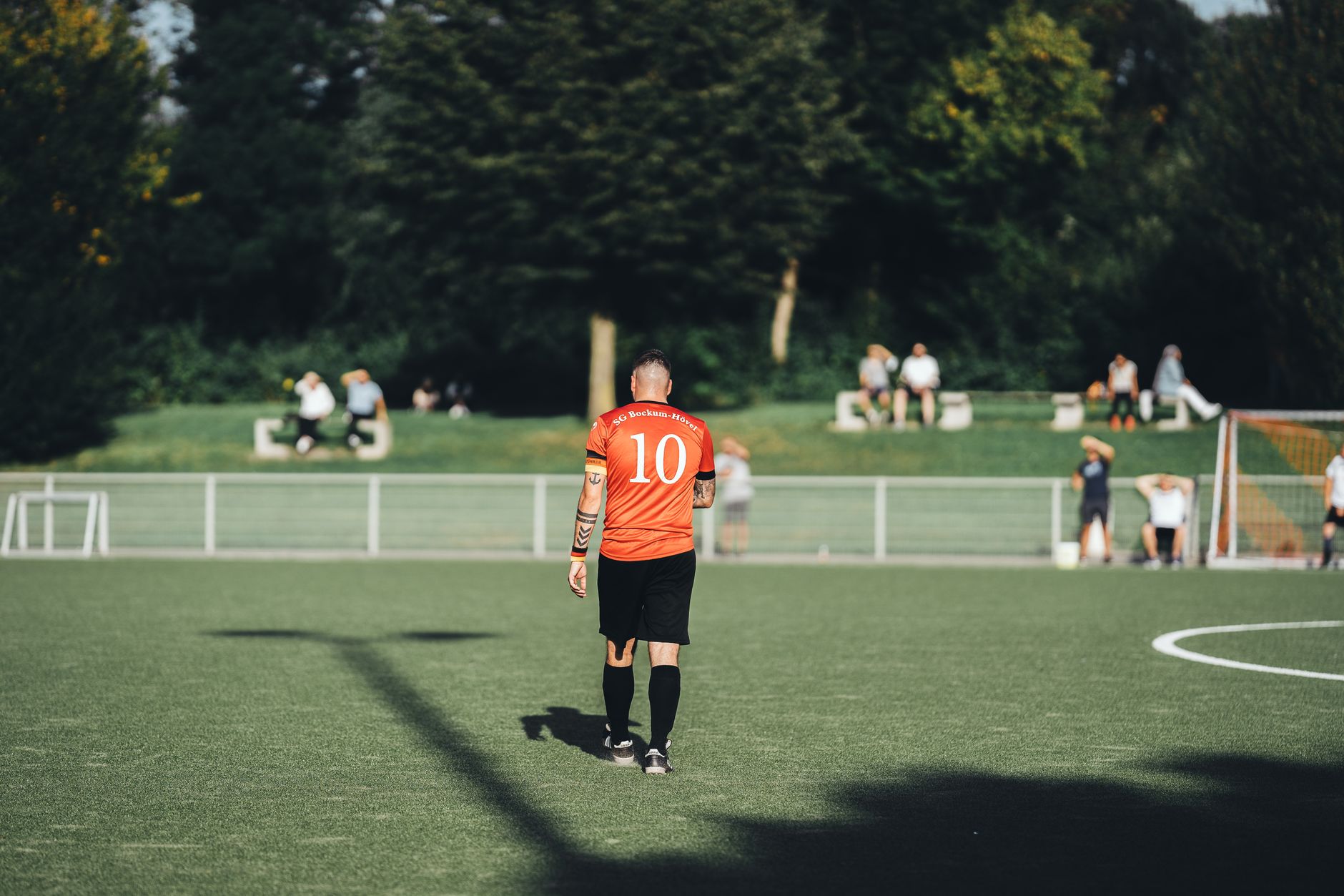 Tampilan belakang pemain sepak bola mengenakan nomor 10 di hari yang cerah.