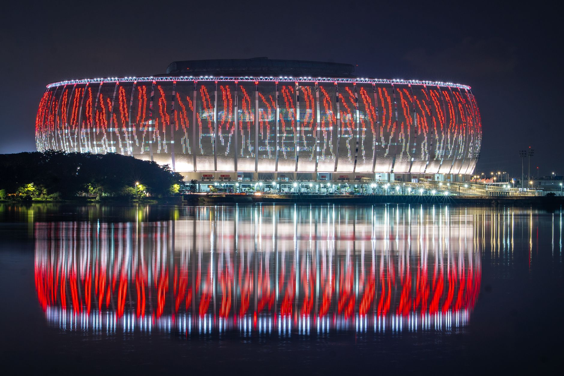 Stadion Lusail yang indah diterangi dengan refleksi di air selama malam di Qatar.