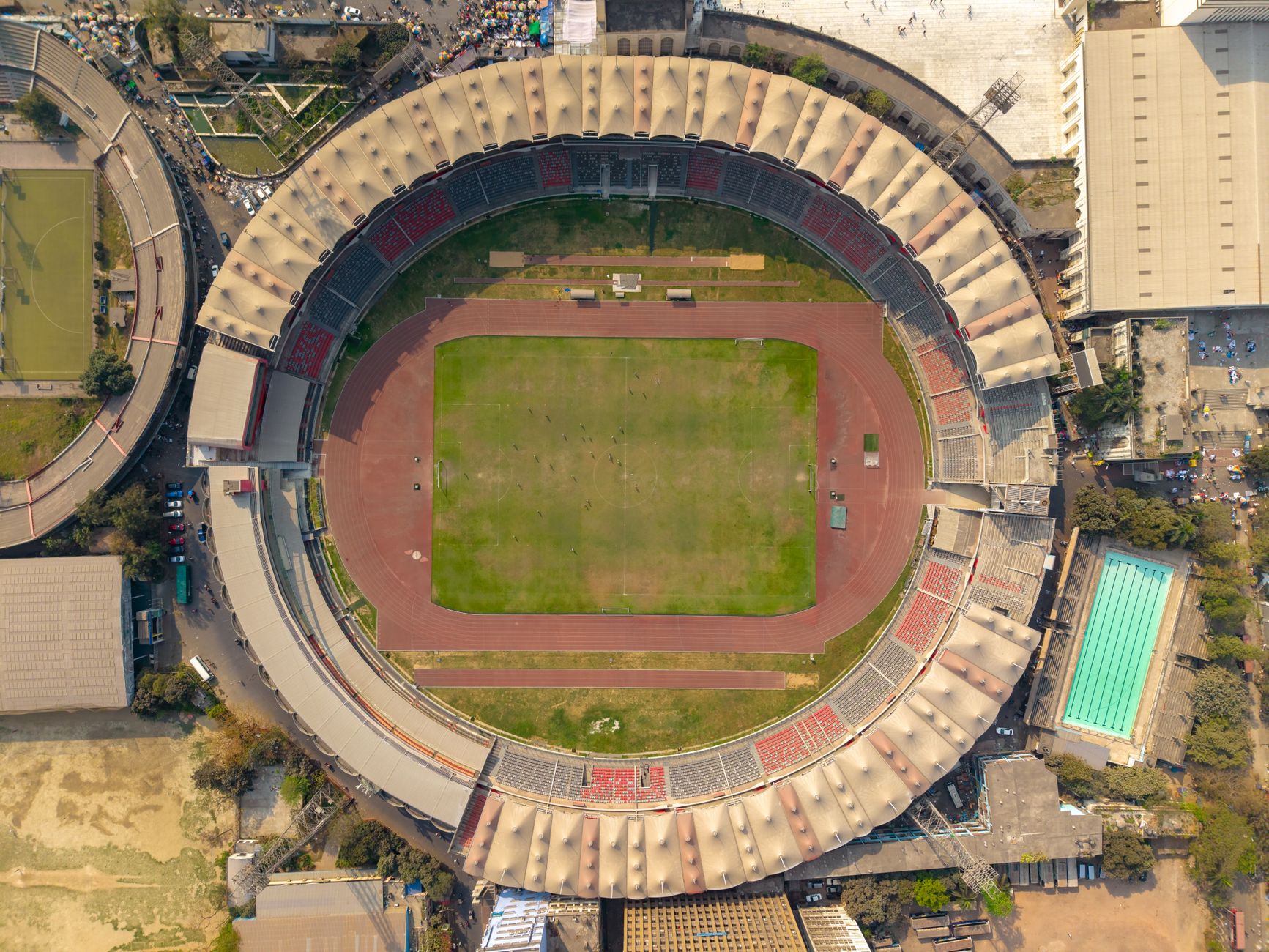 Pemandangan dari atas stadion sepak bola nasional dengan lanskap perkotaan di sekitarnya.
