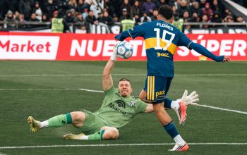 Momen menegangkan dalam pertandingan sepak bola saat kiper berusaha melakukan penyelamatan selama pertandingan.