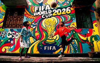 Mural berwarna-warni Piala Dunia FIFA 2026 dengan anak-anak bermain sepak bola di latar depan.
