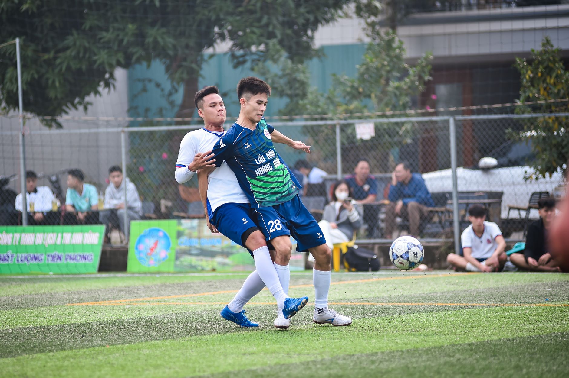 Pemain sepak bola bertarung di lapangan selama pertandingan yang meriah di Hanoi, Vietnam.