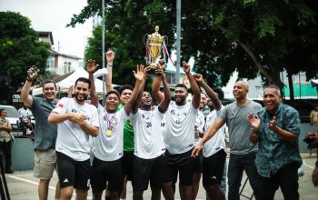 Sebuah tim sepak bola yang gembira merayakan kemenangan mereka dengan trofi di luar ruangan di Kota Panama.