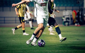 Pertandingan sepak bola seru yang menampilkan aksi para pemain, menangkap intensitas dan keterampilan di lapangan.