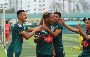 Pemain sepak bola merayakan gol di lapangan dengan semangat dan kerja sama tim.