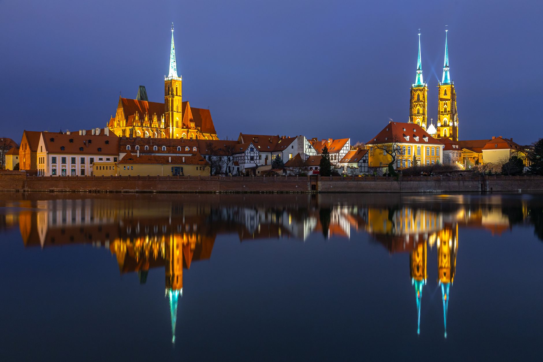 Pemandangan malam yang menakjubkan dari Pulau Katedral yang terpantul di air di Wrocław, Polandia.