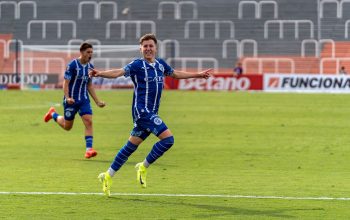 Pemain sepak bola yang gembira merayakan gol di lapangan selama pertandingan.