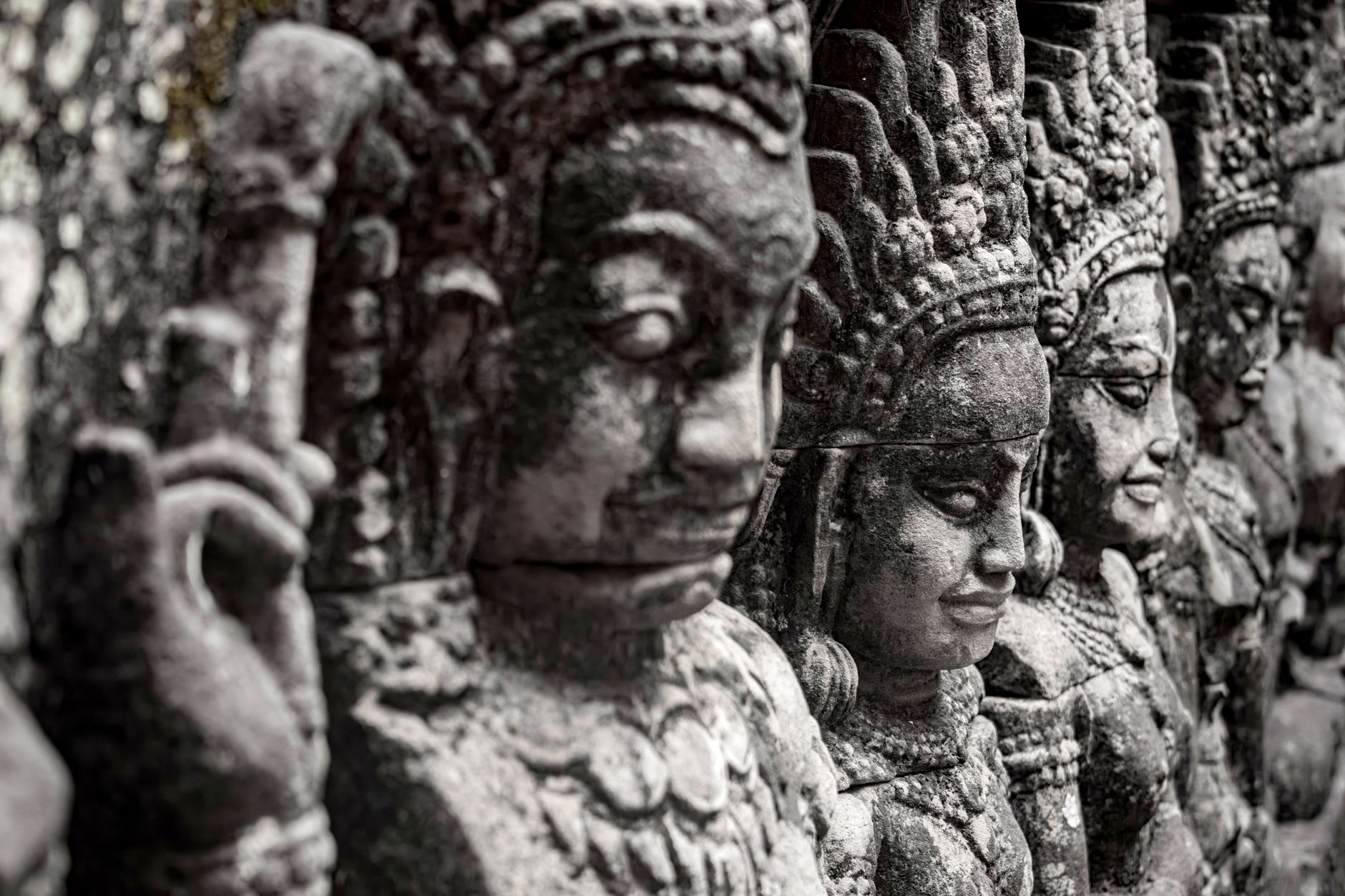 Ukiran batu rinci dewa di Angkor Wat, memamerkan seni dan arsitektur Kamboja kuno.